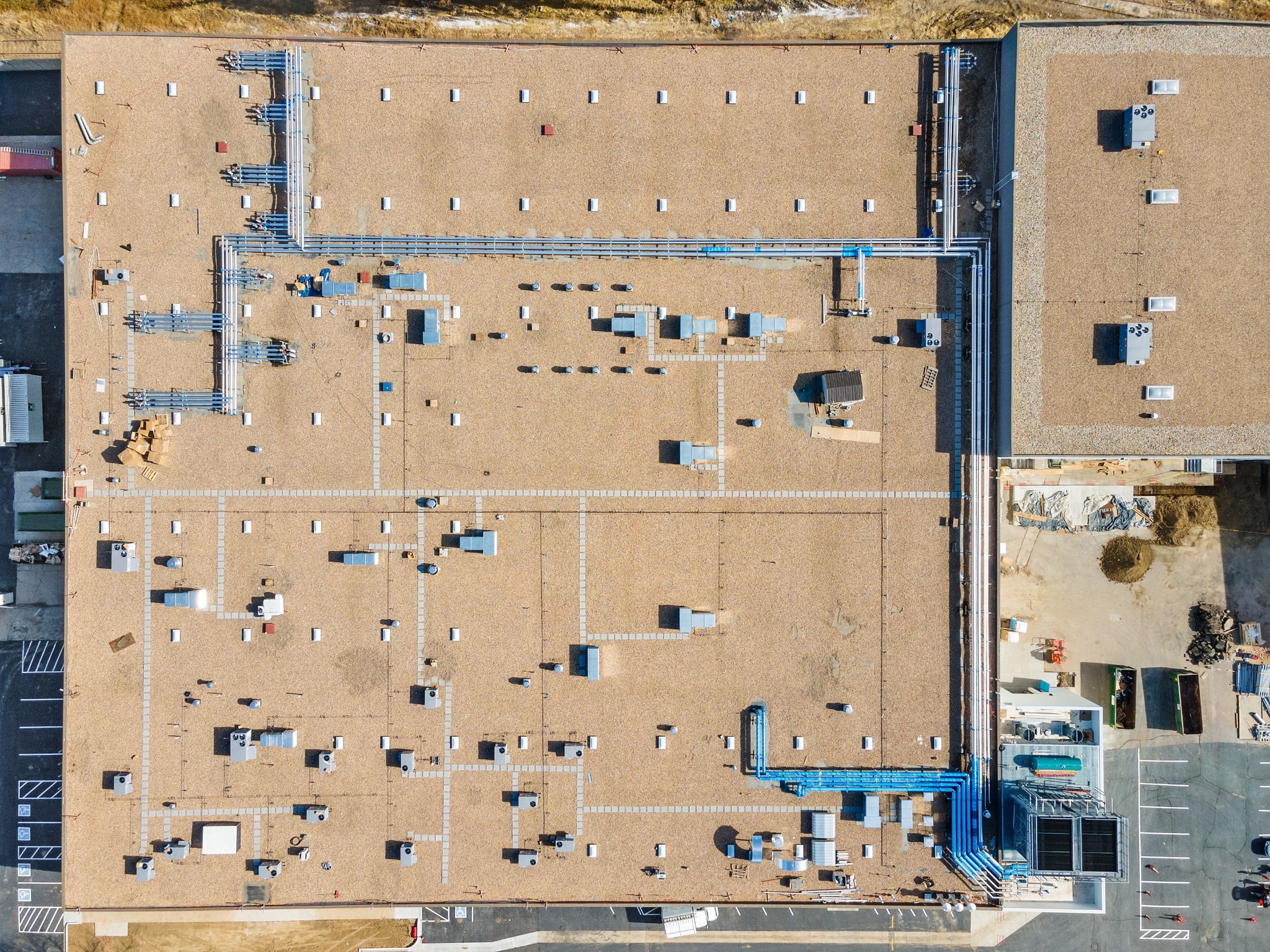 Aerial view of a commercial rooftop cooling system with extensive connected piping