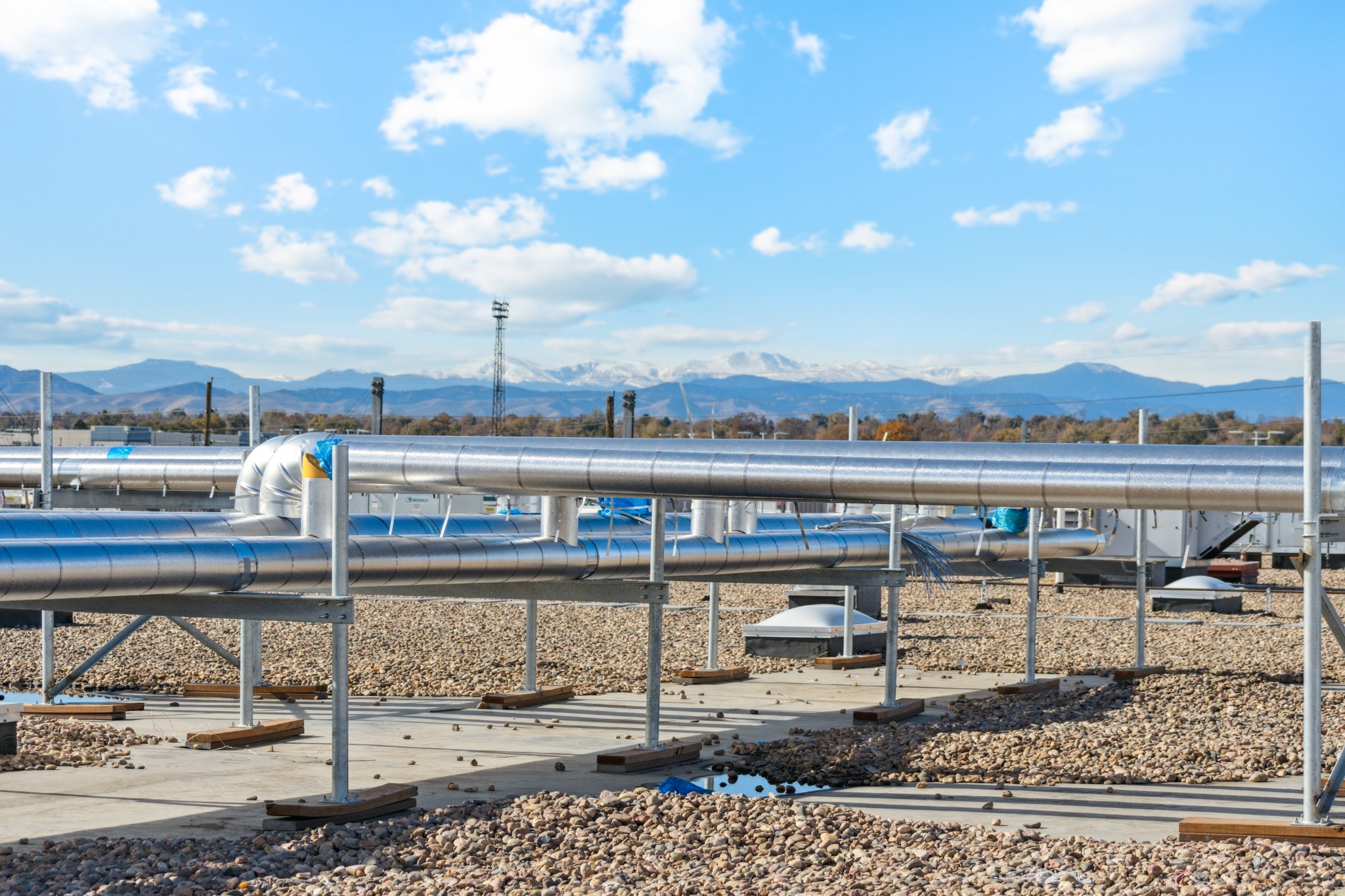 Insulated rooftop cooling-system piping with the Colorado mountains in the distance