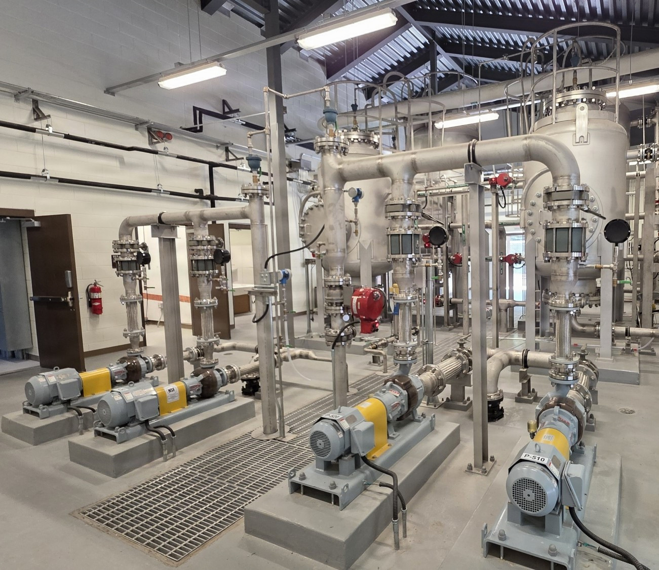 Modern water treatment process equipment with pumps, vessels, valves, and stainless-steel piping